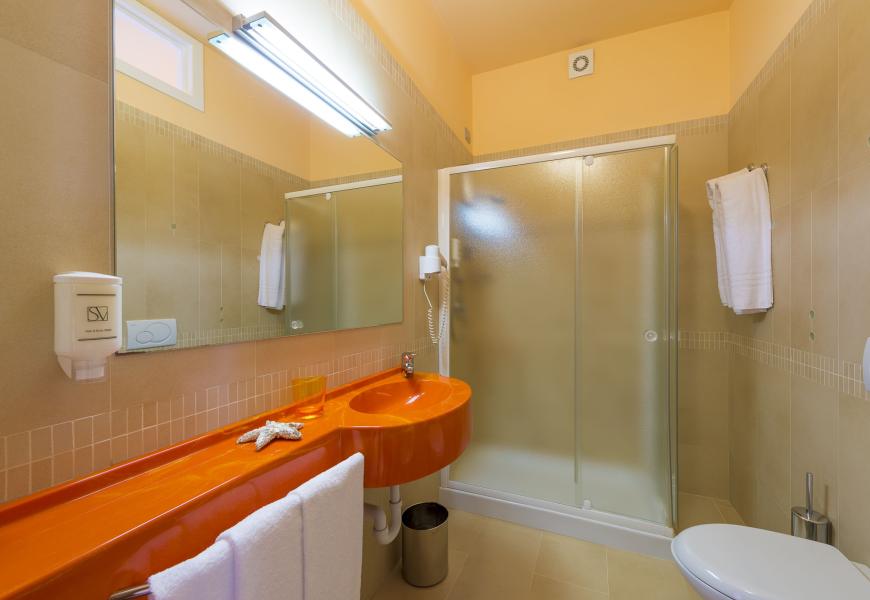 Bagno moderno con lavabo arancione e doccia.
